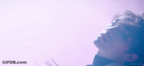A Close Up Of A Man 'S Face With A Purple Background . GIF