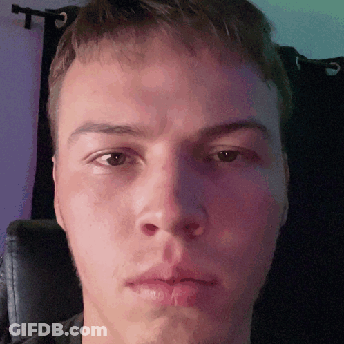 A Close Up Of A Man 'S Face With A Purple Curtain In The Background GIF