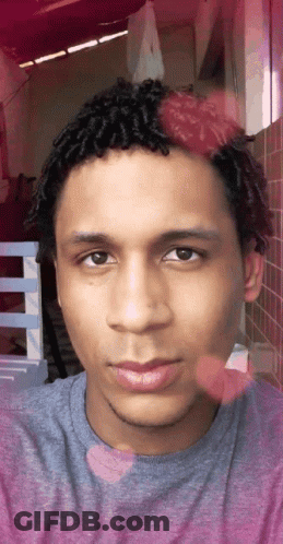 A Close Up Of A Man 'S Face With A Purple Shirt On GIF