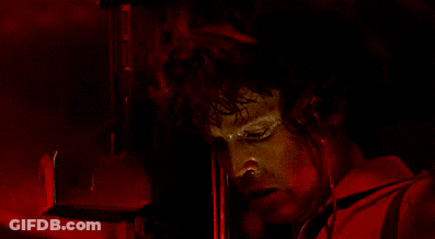 A Close Up Of A Man 'S Face With A Red Light Behind Him GIF