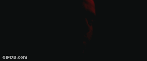 A Close Up Of A Man 'S Face With A Red Light Behind Him GIF