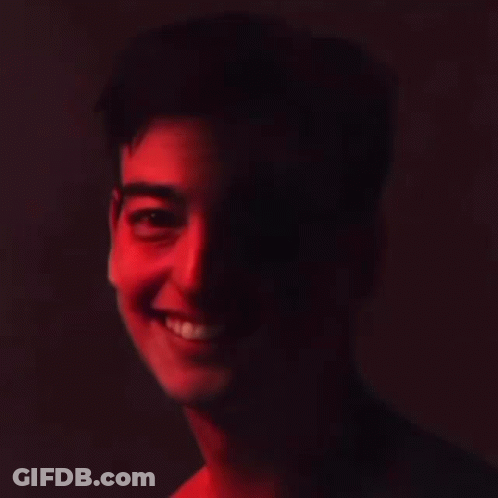 A Close Up Of A Man 'S Face With A Red Light Shining On His Face . GIF
