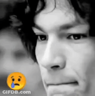 A Close Up Of A Man 'S Face With A Sad Smiley Face Next To It . GIF