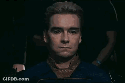 A Close Up Of A Man 'S Face With A Serious Look On His Face In A Dark Room . GIF