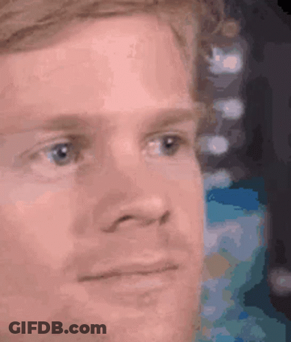A Close Up Of A Man 'S Face With A Slight Smile On His Face . GIF