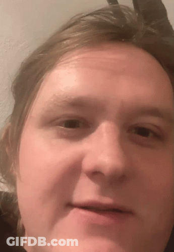 A Close Up Of A Man 'S Face With A Slight Smile GIF