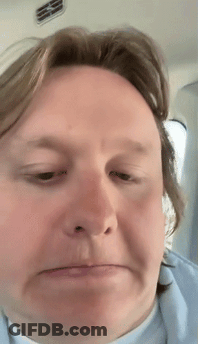 A Close Up Of A Man 'S Face With A Slight Smirk On His Face GIF