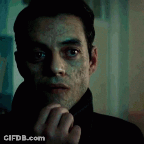 A Close Up Of A Man 'S Face With A Slight Smirk On His Face GIF