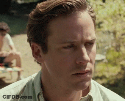 A Close Up Of A Man 'S Face With A Striped Shirt And A Serious Look On His Face . GIF