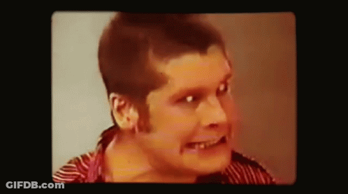 A Close Up Of A Man 'S Face With A Striped Shirt On . GIF