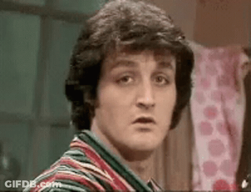A Close Up Of A Man 'S Face With A Striped Shirt On Making A Funny Face . GIF