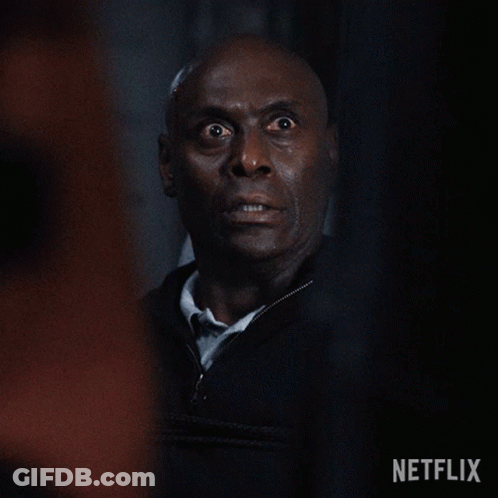 A Close Up Of A Man 'S Face With A Surprised Look On His Face In A Dark Room . GIF