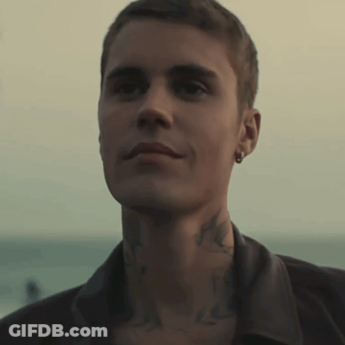 A Close Up Of A Man 'S Face With A Tattoo On His Neck And Earring GIF