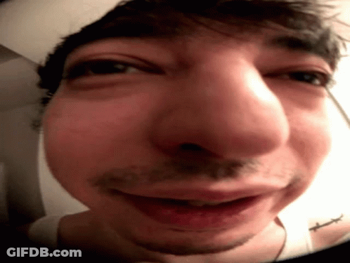 A Close Up Of A Man 'S Face With A Tattoo On His Shoulder GIF