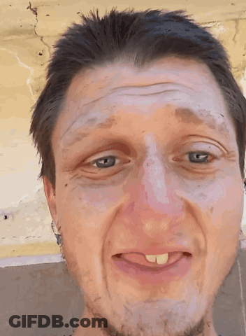 A Close Up Of A Man 'S Face With A Tongue Sticking Out GIF