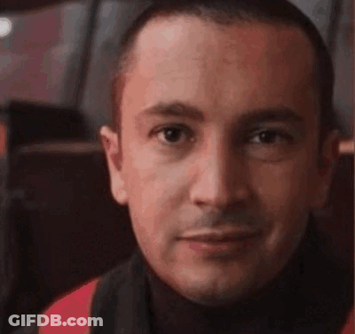 A Close Up Of A Man 'S Face With A Turtleneck And A Scarf Around His Neck . GIF