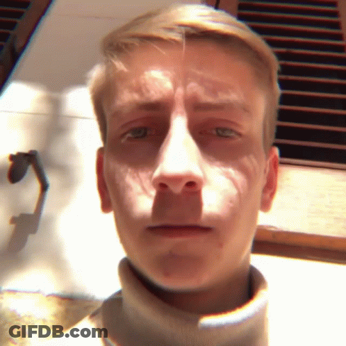 A Close Up Of A Man 'S Face With A Turtleneck Sweater GIF