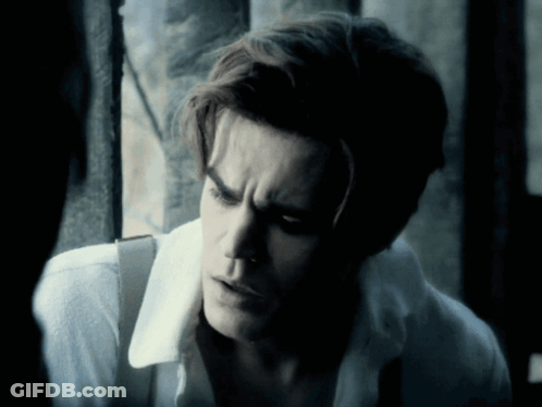 A Close Up Of A Man 'S Face With A White Shirt And Suspenders GIF