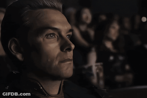 A Close Up Of A Man 'S Face With A Woman In The Background GIF