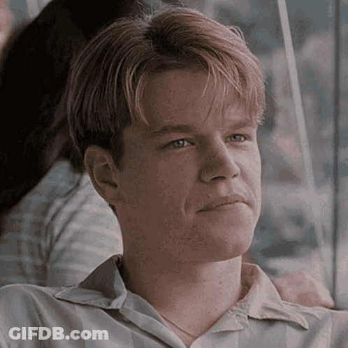 A Close Up Of A Man 'S Face With A Woman 'S Arm Around His Shoulder GIF