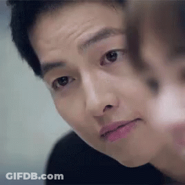 A Close Up Of A Man 'S Face With A Woman 'S Face Behind Him . GIF