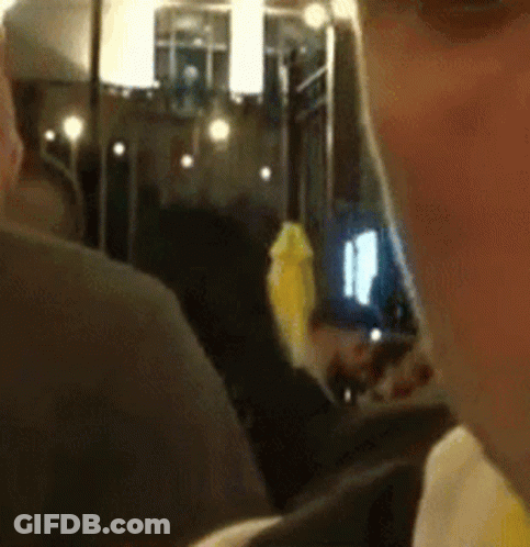 A Close Up Of A Man 'S Face With A Yellow Object In His Mouth GIF