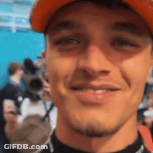 A Close Up Of A Man 'S Face With An Orange Hat On GIF