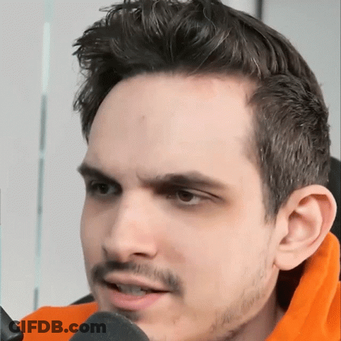 A Close Up Of A Man 'S Face With An Orange Sweater On GIF