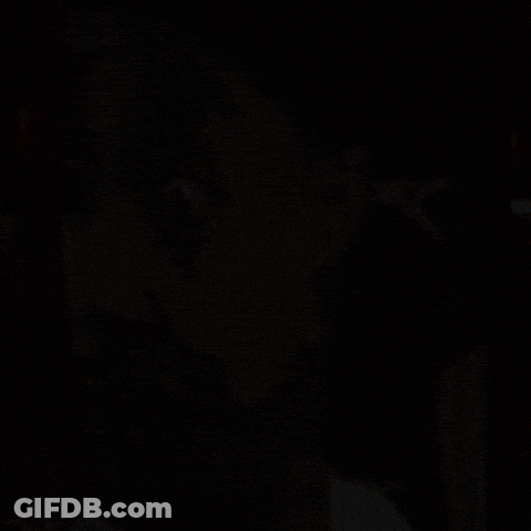 A Close Up Of A Man 'S Face With An X On The Back Of A Chair GIF