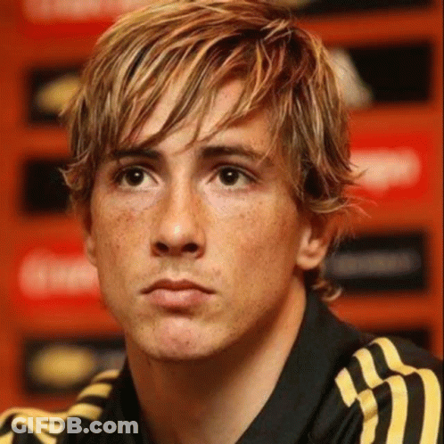 A Close Up Of A Man 'S Face With Blonde Hair And Freckles Wearing A Black And Yellow Adidas Shirt . GIF