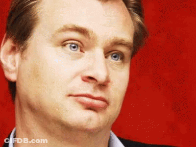 A Close Up Of A Man 'S Face With Blue Eyes Against A Red Background GIF
