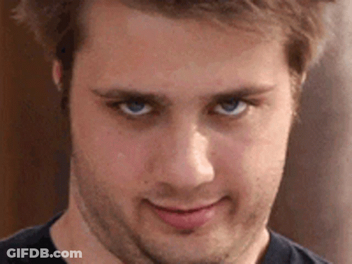 A Close Up Of A Man 'S Face With Blue Eyes And A Beard . GIF