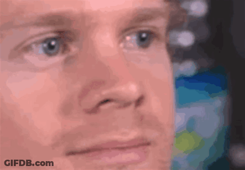A Close Up Of A Man 'S Face With Blue Eyes Looking At Something . GIF