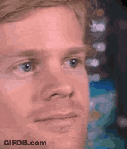 A Close Up Of A Man 'S Face With Blue Eyes Looking At Something . GIF