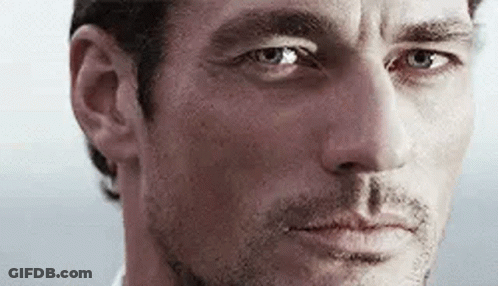 A Close Up Of A Man 'S Face With Blue Eyes Looking At The Camera . GIF