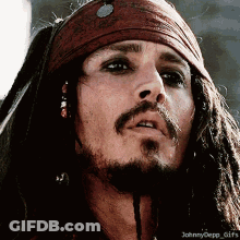 A Close Up Of A Man 'S Face With Dreadlocks And A Bandana On His Head GIF