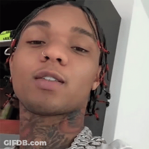 A Close Up Of A Man 'S Face With Dreadlocks And A Tattoo On His Neck GIF