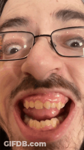 A Close Up Of A Man 'S Face With Glasses And A Mustache GIF