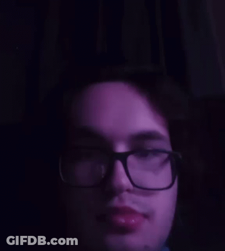 A Close Up Of A Man 'S Face With Glasses And A Purple Background GIF