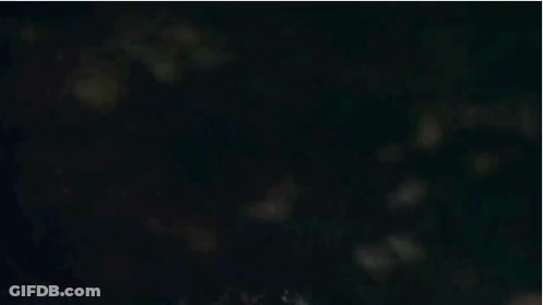 A Close Up Of A Man 'S Face With Glowing Eyes And A Red Jacket . GIF