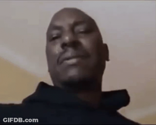 A Close Up Of A Man 'S Face With His Eyes Closed And A Black Hoodie On . GIF