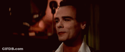 A Close Up Of A Man 'S Face With His Eyes Closed And A Microphone In The Background . GIF