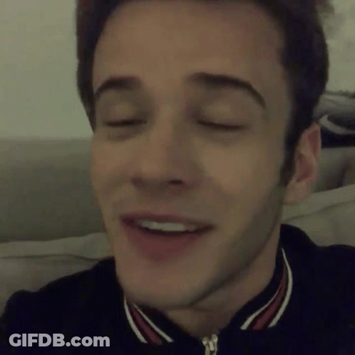 A Close Up Of A Man 'S Face With His Eyes Closed And A Smile On His Face GIF