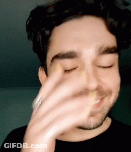 A Close Up Of A Man 'S Face With His Eyes Closed And His Hand On His Face . GIF