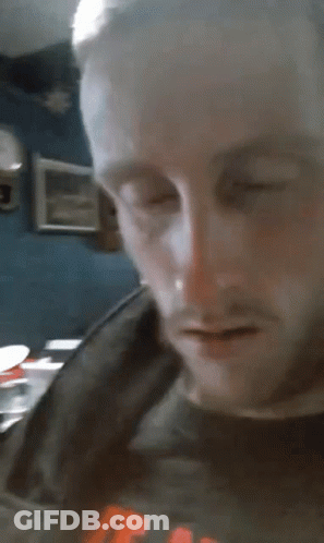 A Close Up Of A Man 'S Face With His Eyes Closed And His Mouth Open GIF