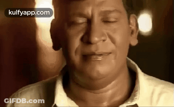 A Close Up Of A Man 'S Face With His Eyes Closed And His Mouth Open . GIF