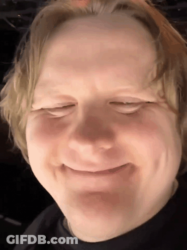 A Close Up Of A Man 'S Face With His Eyes Closed And Smiling GIF