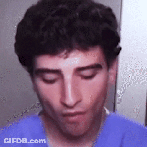 A Close Up Of A Man 'S Face With His Eyes Closed Wearing A Blue Shirt . GIF