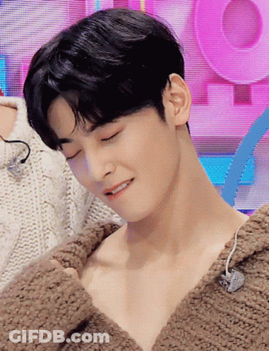 A Close Up Of A Man 'S Face With His Eyes Closed Wearing A Brown Sweater GIF