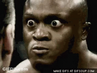 A Close Up Of A Man 'S Face With His Eyes Wide Open Looking At Another Man . GIF